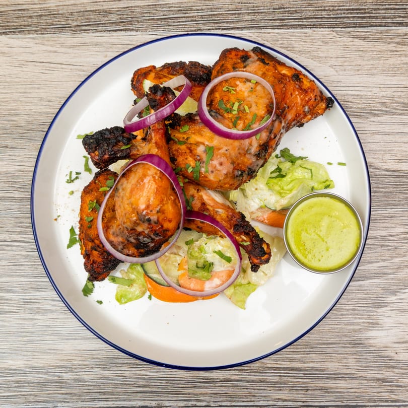 Magic Pepper's Indian tandoori chicken with red onion, cilantro, salad, and green chutney.